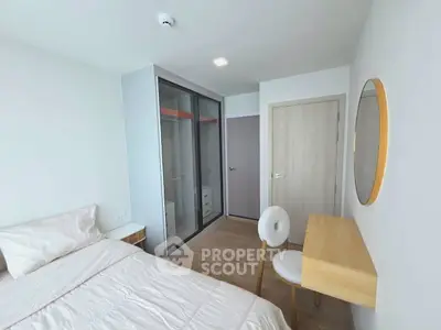 Modern bedroom with minimalist design, featuring a cozy bed, sleek wardrobe, and stylish vanity desk.