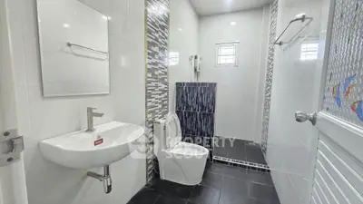 Modern bathroom with sleek design and tiled walls in a contemporary home.