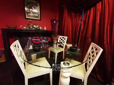Chic dining area with glass table and elegant chairs in a stylishly decorated room.