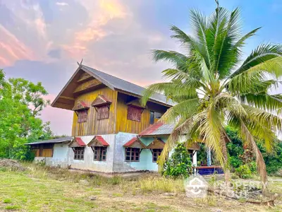 Charming rustic two-story house with lush garden and tropical palm tree