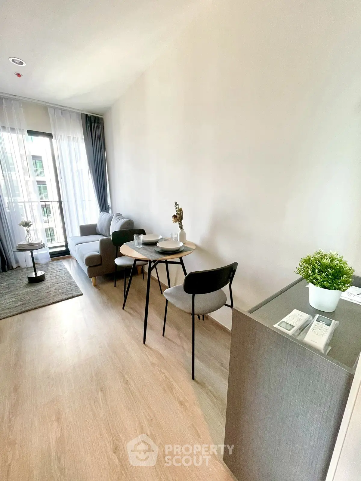 Modern living room with stylish decor and natural light, featuring a cozy seating area and dining space.