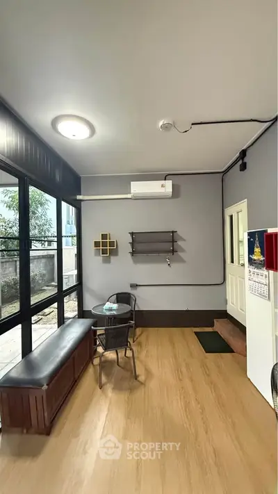 Charming small living area with modern decor and large windows for natural light.