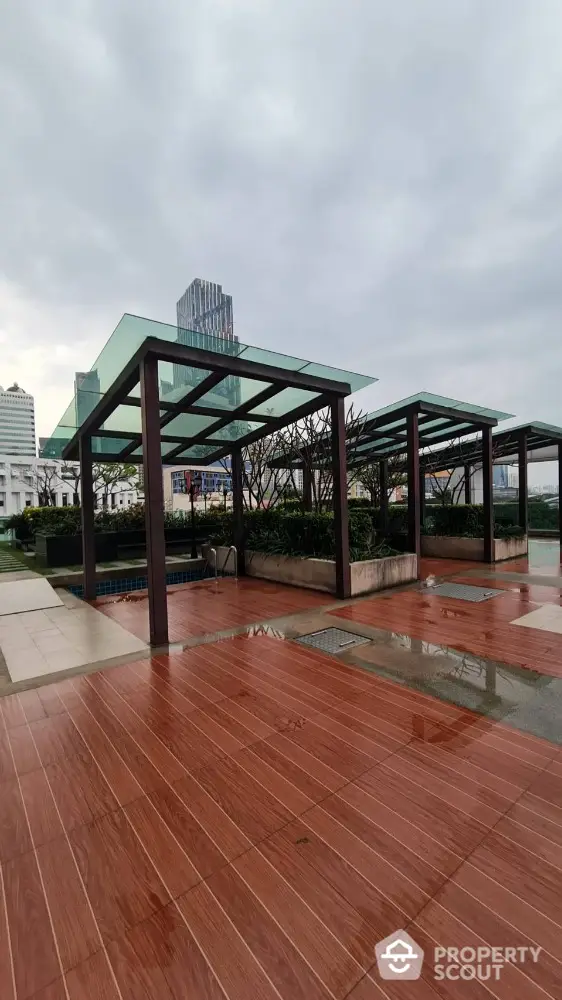 Modern rooftop terrace with glass pergolas and city skyline view