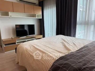 Modern bedroom with stylish decor, large window, and mounted TV for a cozy living experience.
