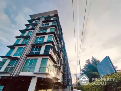 Modern multi-story apartment building with large windows and contemporary design.