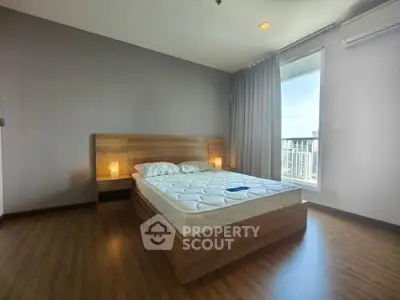Spacious bedroom with modern decor and city view, featuring a comfortable bed and natural light.