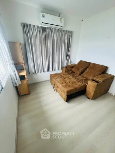 Cozy living room with brown sofa and air conditioning, perfect for relaxation.