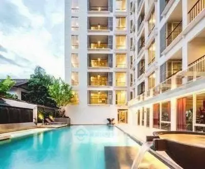 Luxurious apartment building with stunning poolside view and modern architecture.