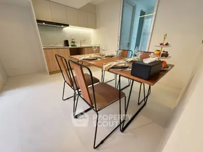 Modern dining area with stylish table and chairs adjacent to a sleek kitchen.