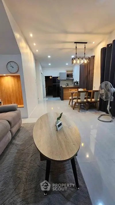 Modern open-plan living and dining area with stylish lighting and contemporary furniture.