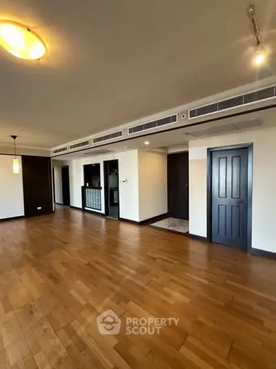 Spacious modern living room with wooden flooring and stylish lighting