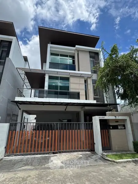 Modern three-story house with sleek design and spacious balcony in urban setting.