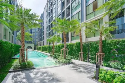 Luxurious modern apartment complex with stunning pool and lush greenery