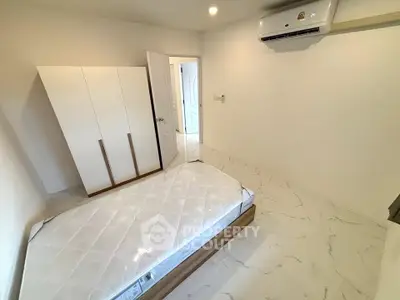 Minimalist bedroom with white wardrobe and air conditioning unit