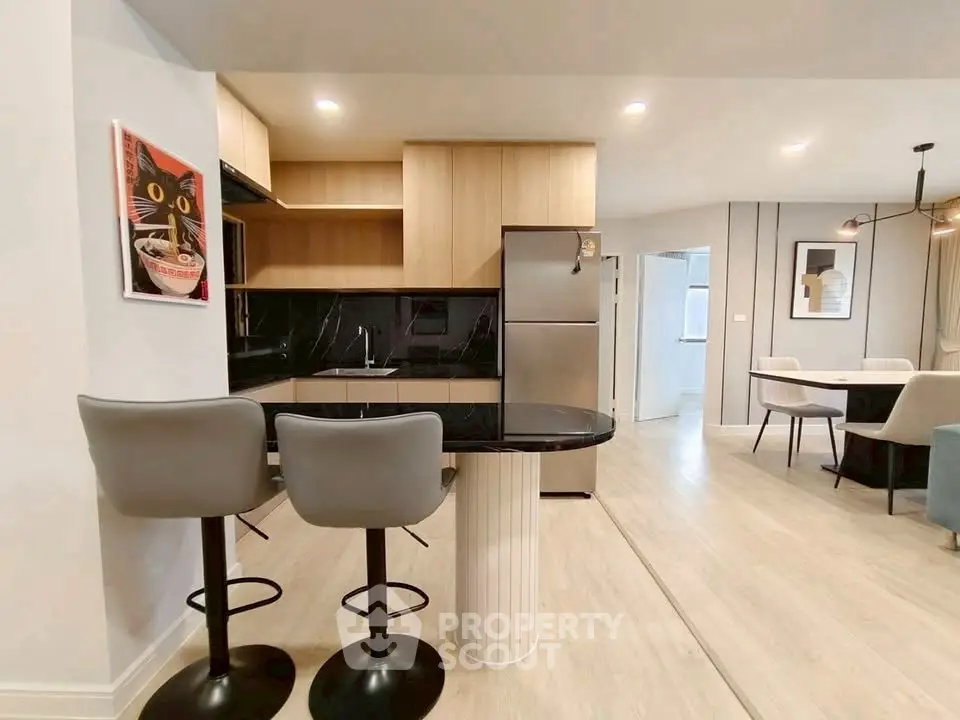 Modern kitchen with sleek black countertops and stylish bar stools