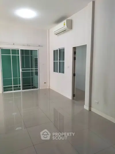 Spacious modern living room with sleek tile flooring and air conditioning, perfect for comfortable living.