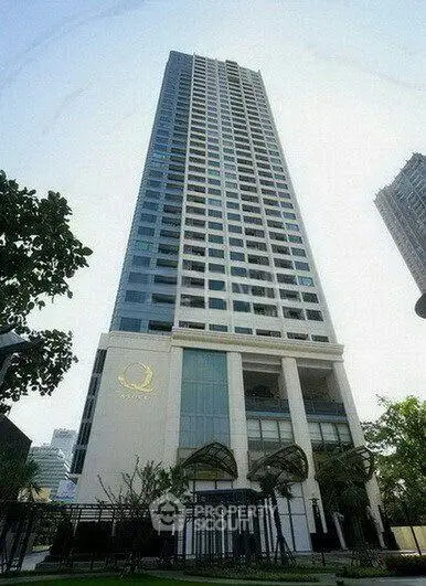Stunning high-rise building with modern architecture and lush greenery in urban setting.