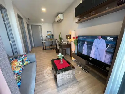 Modern living room with stylish decor and large TV, perfect for relaxation and entertainment.