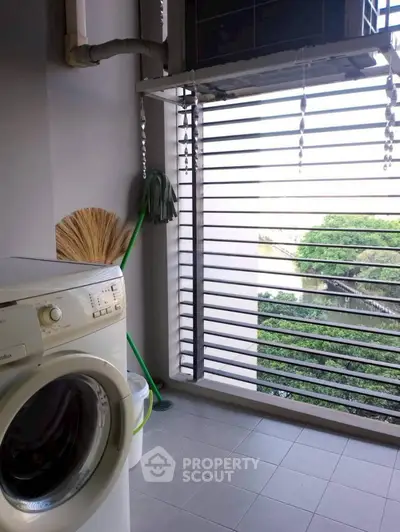 Laundry area with washing machine and outdoor view, perfect for urban living convenience.
