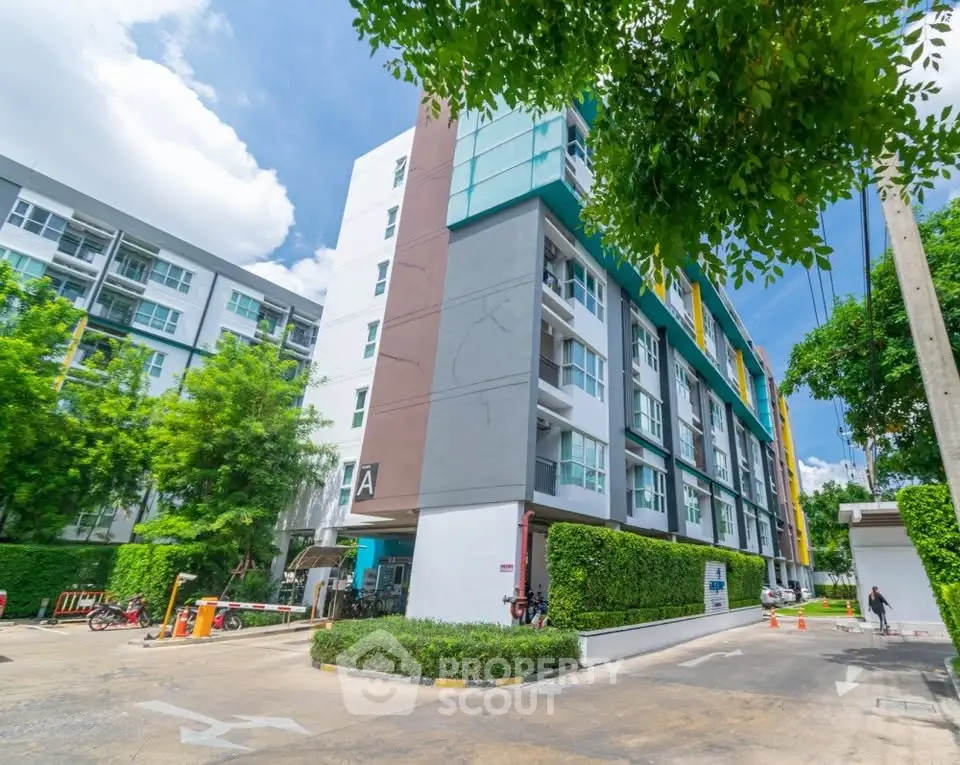 Modern apartment building with lush greenery and clear blue sky, ideal for urban living.