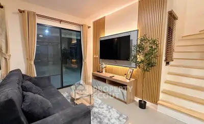 Modern living room with sleek design, large TV, and cozy seating area