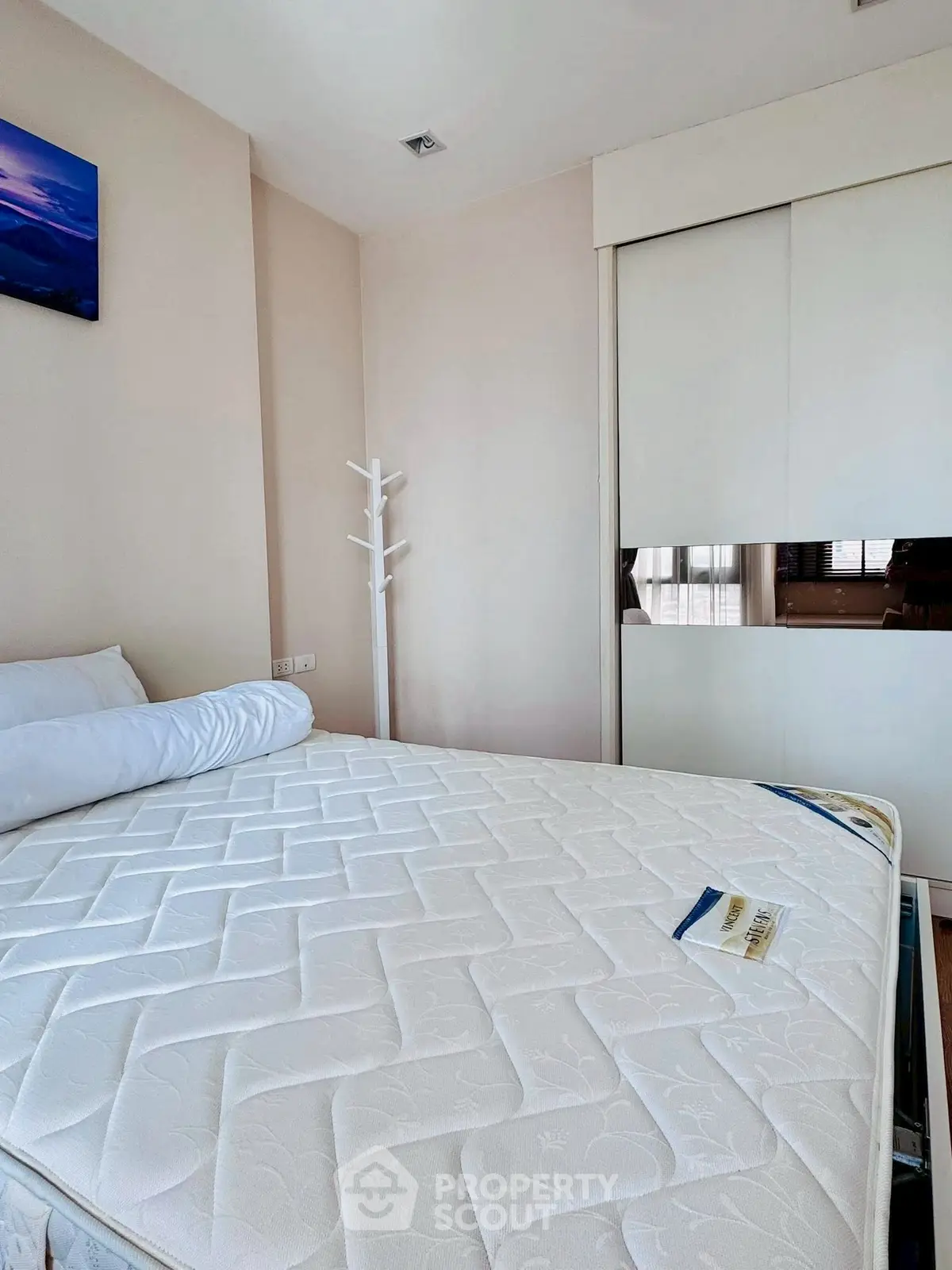 Cozy bedroom with a large bed and built-in wardrobe, perfect for relaxation and storage.