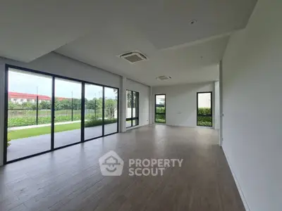 Spacious modern living room with large windows and garden view