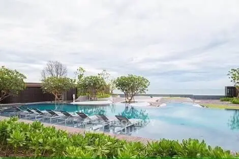 Luxurious rooftop pool with sun loungers and ocean view, perfect for relaxation and leisure.