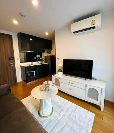 Modern living room with sleek kitchen, air conditioning, and stylish decor in a cozy apartment.