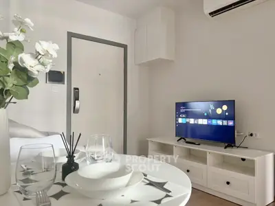 Modern living room with smart TV and stylish decor in a cozy apartment.