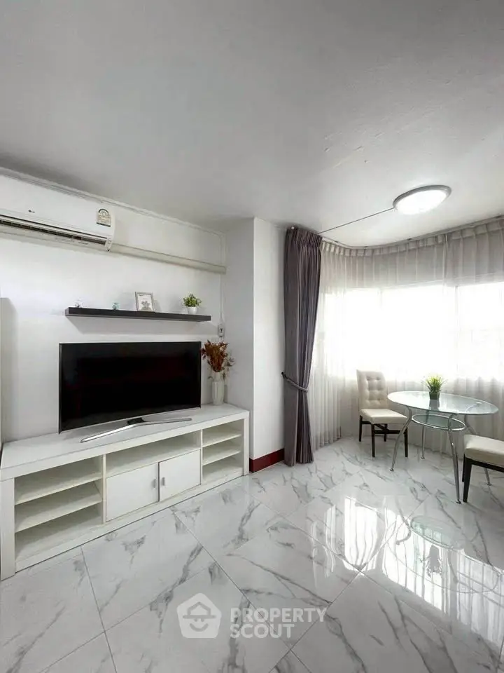 Bright and modern living room with marble flooring and sleek furniture.