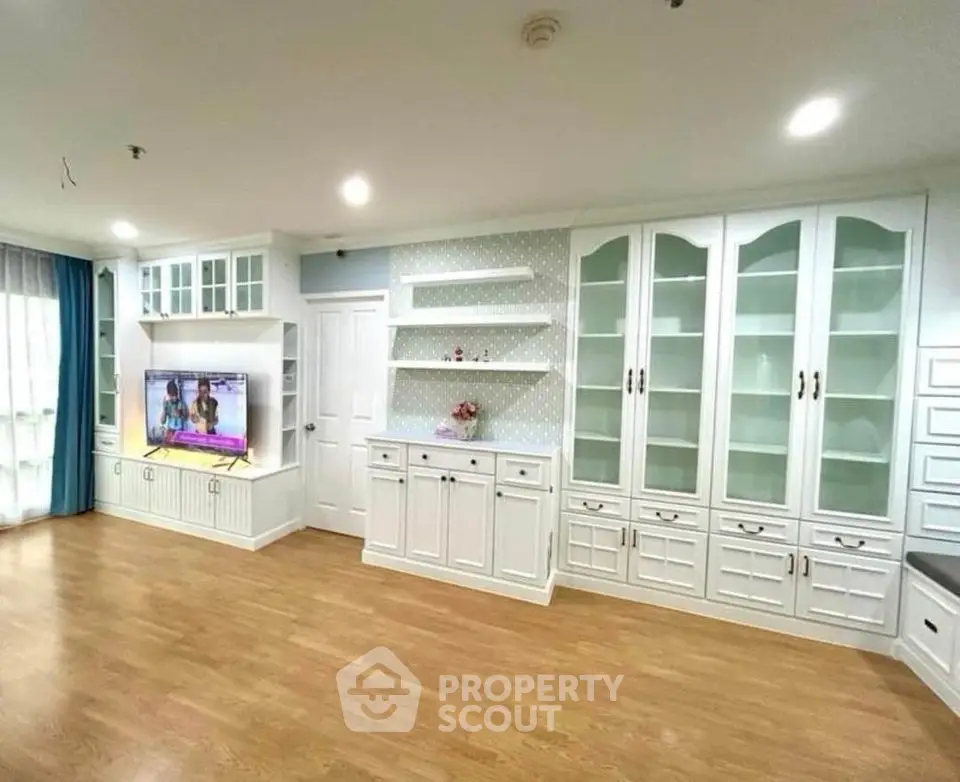 Spacious living room with elegant built-in cabinets and modern TV setup