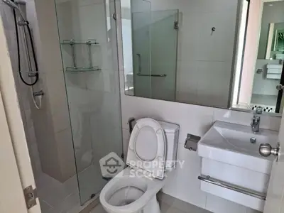 Modern bathroom with glass shower and sleek fixtures in a contemporary apartment.
