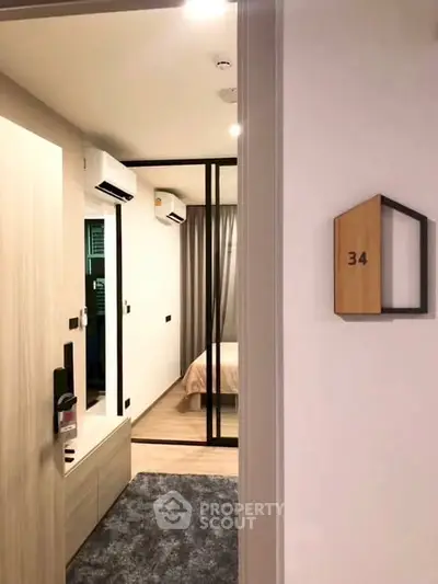 Modern apartment entrance leading to a cozy bedroom with stylish decor.