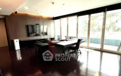 Spacious living room with large windows and modern decor, perfect for relaxation and entertainment.