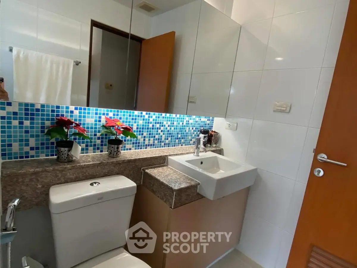Modern bathroom with mosaic tile backsplash and sleek fixtures