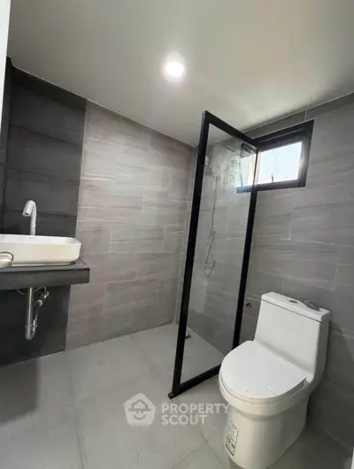 Modern bathroom with sleek design, featuring a glass shower enclosure and contemporary fixtures.
