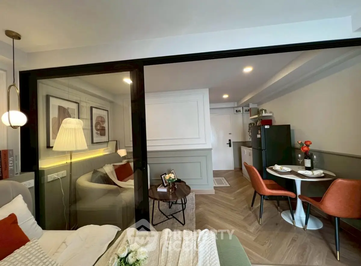 Modern studio apartment with cozy living area and dining space, featuring stylish decor and natural lighting.