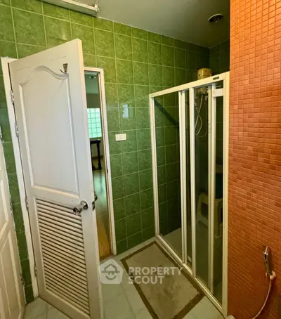 Charming bathroom with vibrant green tiles and modern shower enclosure