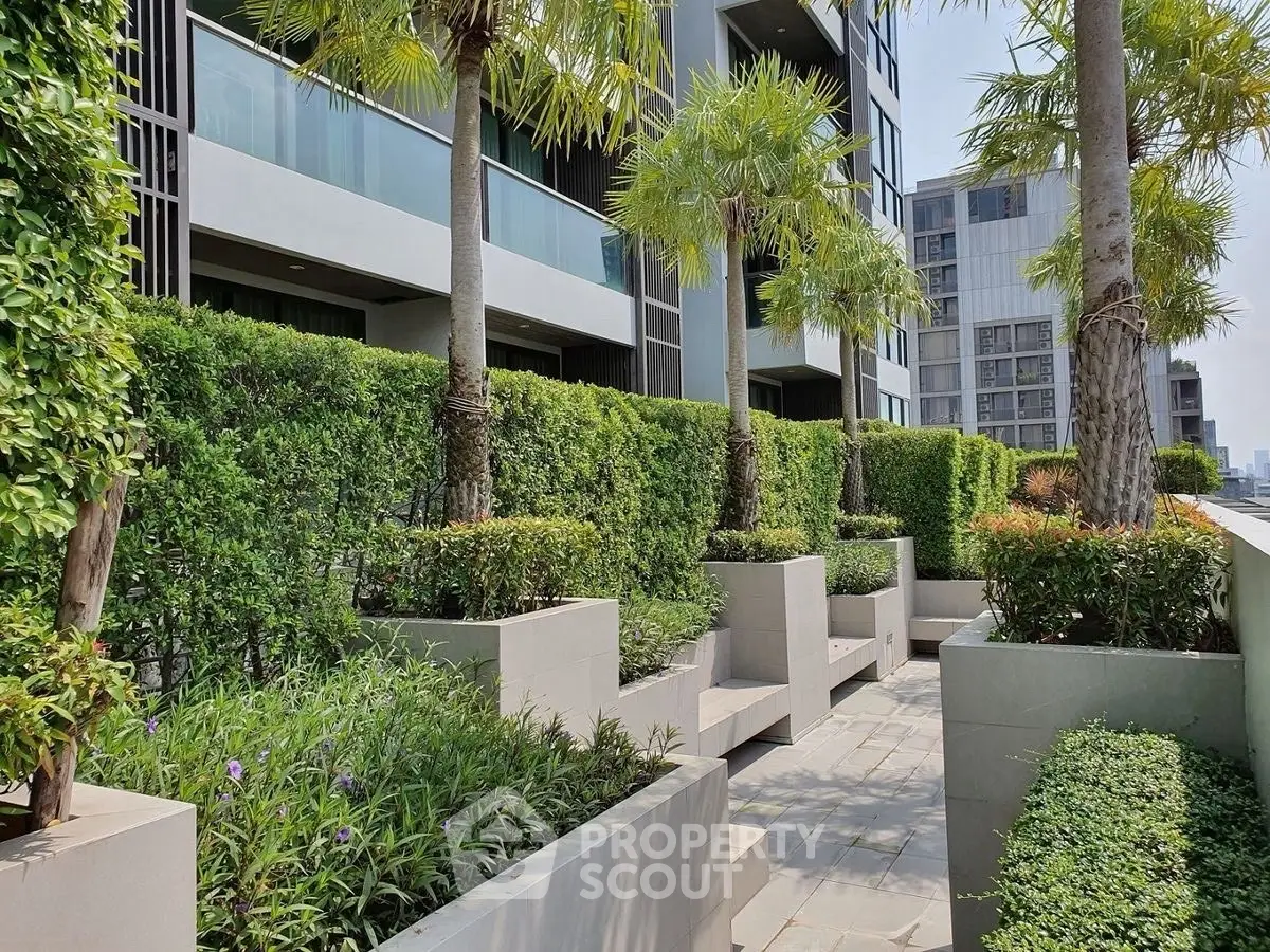 Modern building exterior with lush garden and palm trees