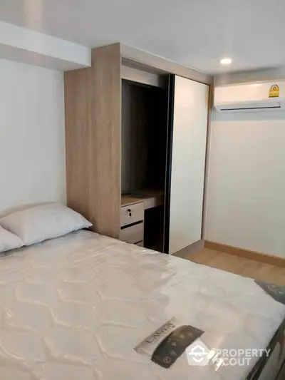 Modern bedroom with built-in wardrobe and air conditioning unit