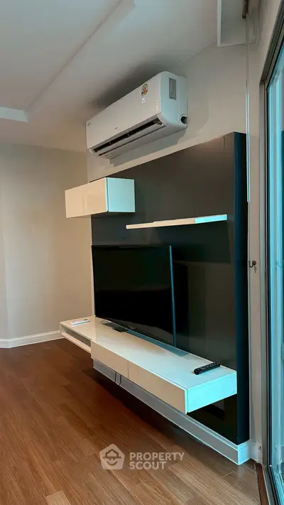 Modern living room with sleek TV setup and air conditioning
