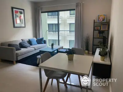 Modern living room with stylish decor and balcony view in urban apartment.