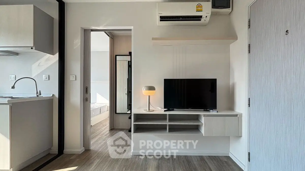Modern apartment interior with sleek design, featuring a cozy living area and compact kitchen.