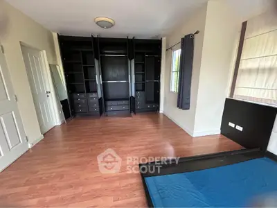 Spacious bedroom with built-in wardrobe and hardwood flooring