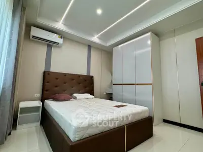Modern bedroom with sleek design, featuring a comfortable bed and ample storage space.