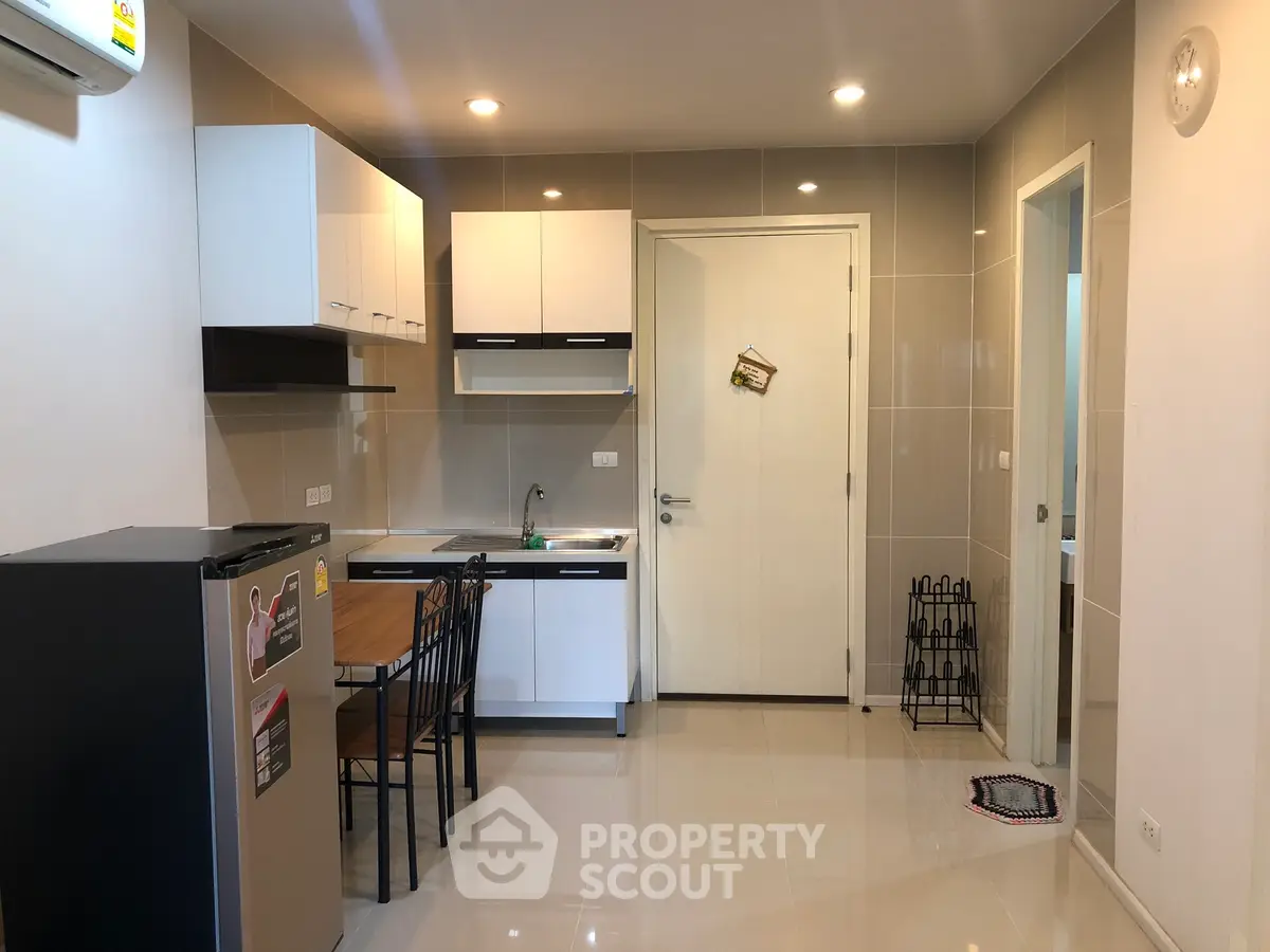 Modern kitchen with sleek cabinets and dining area in stylish apartment