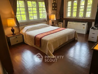 Spacious bedroom with large windows and elegant decor