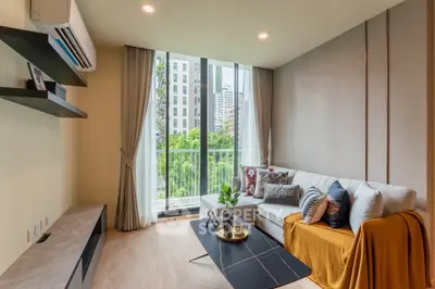 Modern living room with large windows and stylish decor in urban apartment.