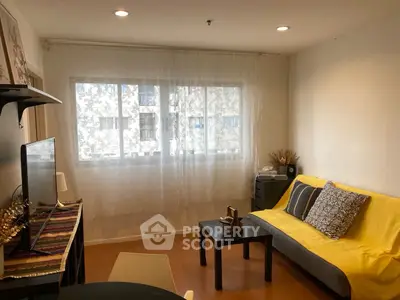 Cozy living room with yellow sofa and modern decor, perfect for relaxation.
